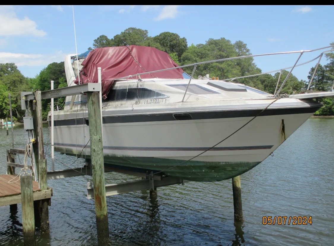Fishing boat being lifted and aligned onto a trailer for salvage