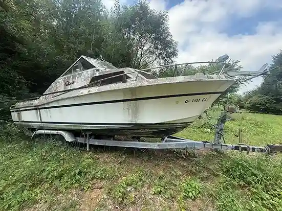 Weathered boat hull in a storage yard awaiting removal